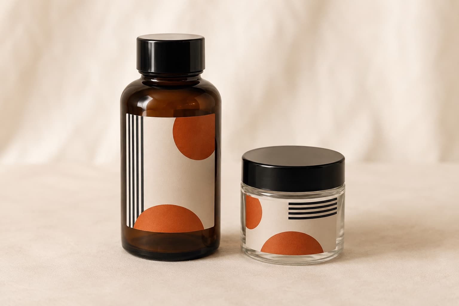 Braunglasflasche und klares Glasgefäß, beide mit einem cremefarbenen Vinyletikett mit orangem Halbkreis