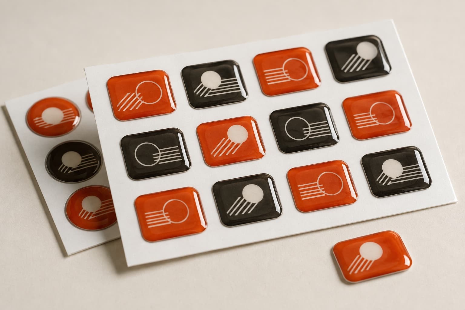 Sheet of rectangular resin domed stickers in orange and anthracite, each under a thick glossy dome